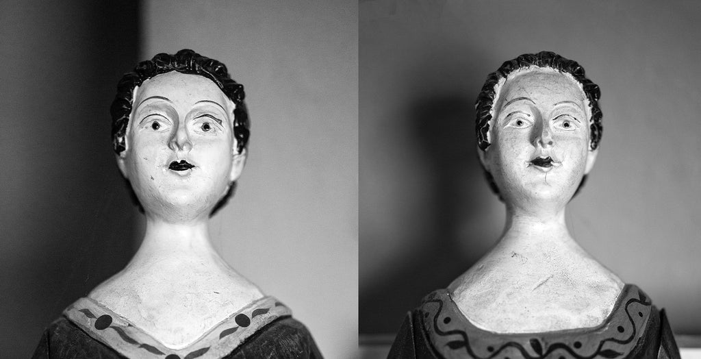Black and white portraits of two antique wooden dolls found in an old southern house