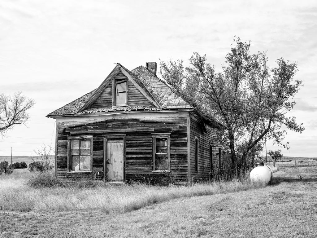 Black and white photograph of an abandoned wooden house in the ghost town at Cottonwood, South Dakota.