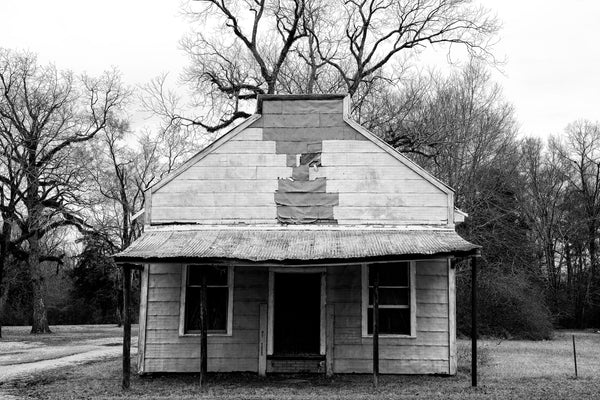 Black and white photograph of the front of an old store building now abandoned in the small rural community of Newbern, Alabama.