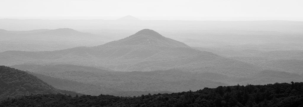 Black and white panoramic landscape photograph of the layers of peaks in the Blue Ridge Mountains in Northern Georgia at sunrise.