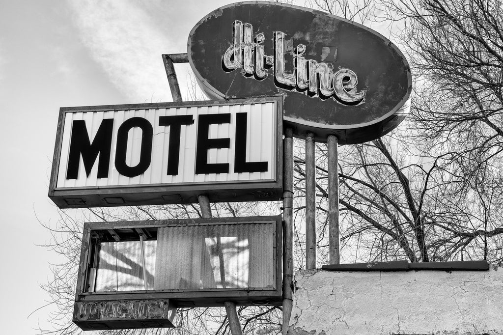 Black and white photograph of the vintage sign for the old Hi-Line Motel along Route 66 in Ash Fork, Arizona. Built in 1936 and originally called the Hi-Line Modern Motor Court, this sign was installed in the late 1950s when the highway was widened to separate Route 66 into divided lanes.