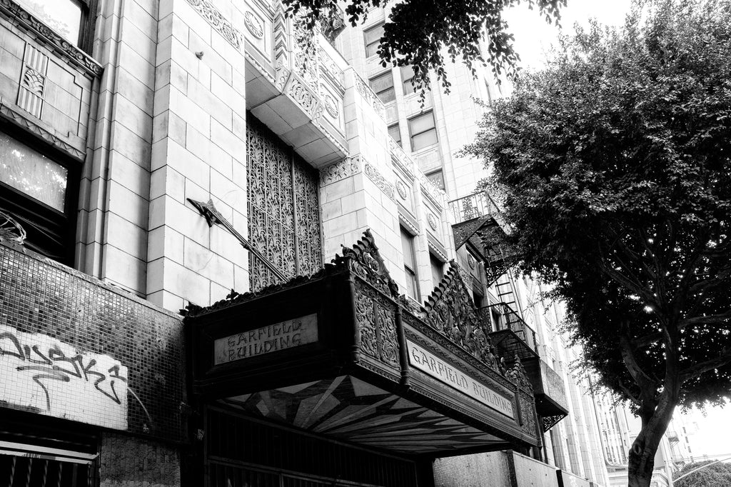 Black and white photograph of the ornate ironwork marquee sign for the art deco Garfield Building, which opened in downtown Los Angeles in 1930 and served as an office building until it became vacant in 1991.