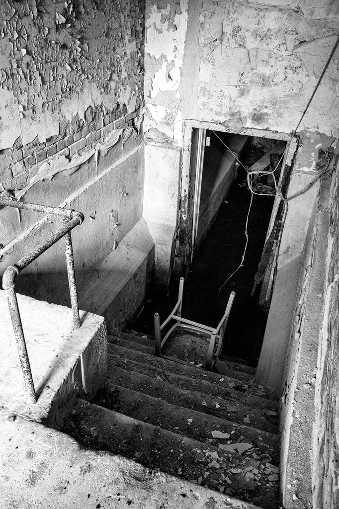 Black and white photograph of the steps down to the flooded basement inside the abandoned 1894 jail in Tunica, Mississippi.