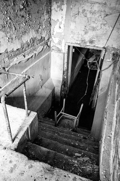 Black and white photograph of the steps down to the flooded basement inside the abandoned 1894 jail in Tunica, Mississippi.