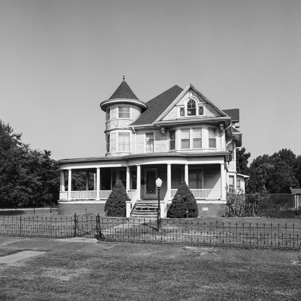Black and white photograph of a beautiful big old house on a quiet street in a small town in the American Midwest. This photograph was shot on medium format black and white film using a vintage Hasselblad camera. Film photography provides a different look than digital photography and prints will display a pleasing amount of film grain and may appear somewhat softer than modern digital images. Be sure to look at the cropped detail images before buying.