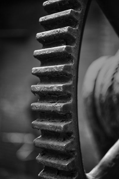 Black and white industrial photograph of a big gear wheel at Sloss Furnaces in Birmingham, Alabama.