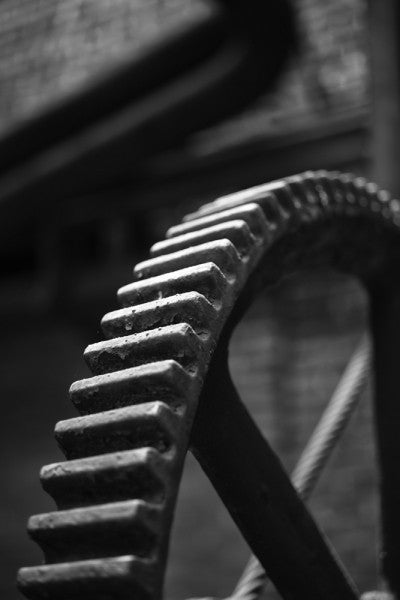 Black and white industrial photograph of a big gear wheel at Sloss Furnaces in Birmingham, Alabama.