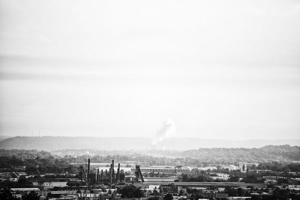 Black and white photograph of industrial Birmingham, Alabama in a long view, including the chimneys of Sloss Furnaces.