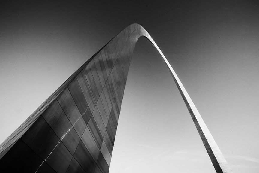 Black and white photograph of the famous St. Louis Gateway Arch catching the last rays of light at sunset.
