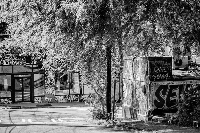 Black and white photograph of sunlight in the trees in a funky section of the Little Five Points neighborhood in Atlanta.