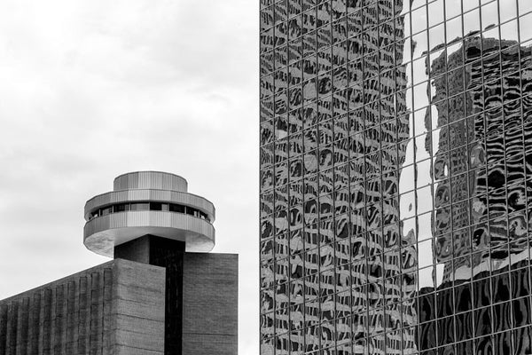 Black and white photograph of downtown Houston, with reflective glass skyscrapers and the rotating hotel restaurant known as Spindletop. 