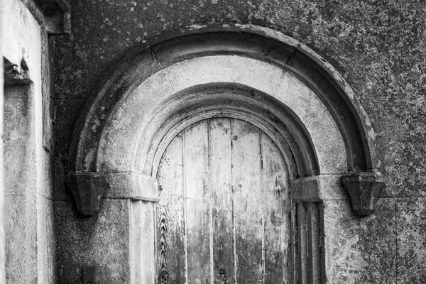 Black and white photograph of an old wooden door set under an arch, flanking the main front entrance to the old Charleston County Jail, which was built in 1802.