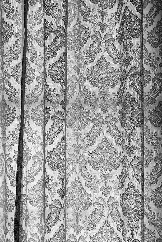Black and white photograph of lace curtains in the old lighthouse keeper's residence at the St. Augustine Lighthouse in Florida.