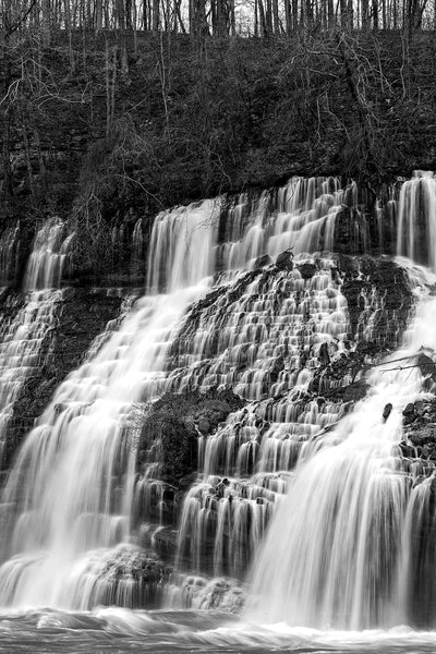Black and white landscape photograph of a wide waterfall cascading in streams down an entire mountainside.