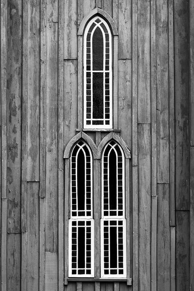Black and white photograph of a trio of windows on a historic Gothic Revivalist church constructed from wood in the mid 1850s.