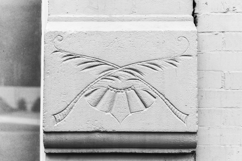 Black and white photograph an architectural detail of a floral impression in the exterior of a historic building in Nashville.