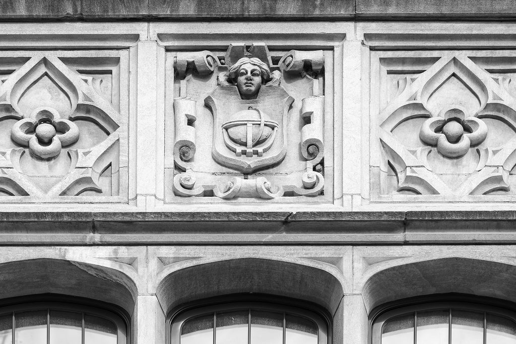 Black and white photograph of a carved stone face on the front of Nashville's historic Hume-Fogg High School, which merged from two schools in 1912, with roots back to 1855. Hume-Fogg's notable alumni include the late entertainer Dinah Shore and 1950s pin-up model Bettie Page.