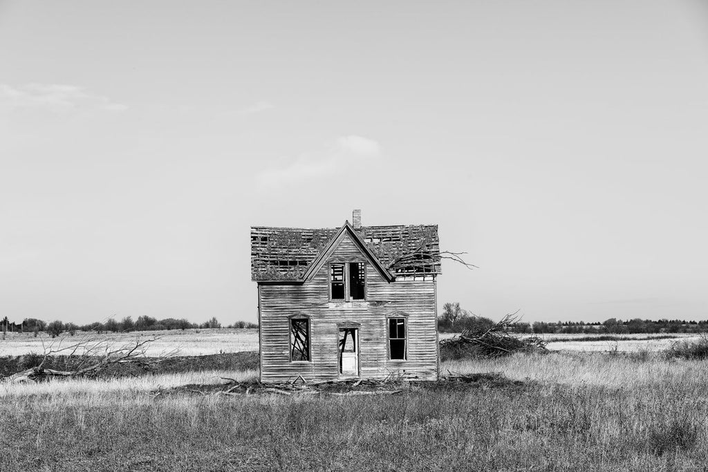 Black and white fine art photograph of an abandoned old wooden farmhouse, commonly known as the Marquette house, on the Kansas prairie.