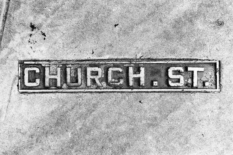 Black and white photograph of a Church Street sidewalk sign in historic Charleston, South Carolina.