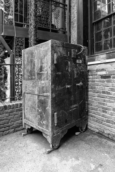 Black and white photograph of a big, rusty, antique safe sitting outside in Nashville's popular Printer's Alley entertainment district.