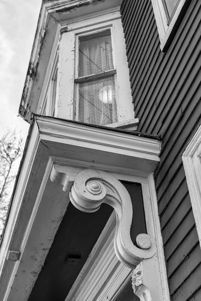 Black and white architectural detail photograph of the woodwork on an old Victorian house.