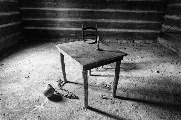 Black and white photograph of the historic log cabin jail in Danville, Kentucky that once held the Harpe brothers, notorious as America's first serial killers.