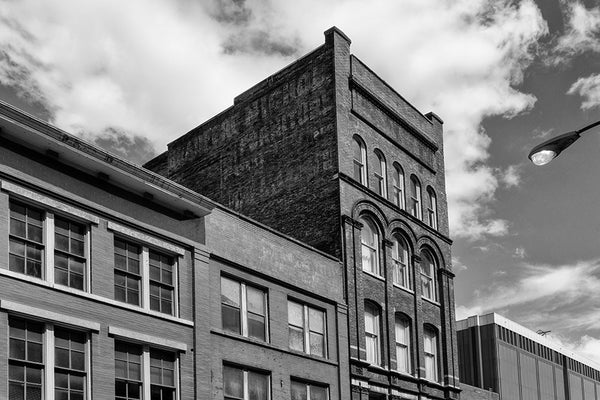 Black and white architectural photograph of a five-story brick building at 208 N. Third in Nashville, Tennessee. Constructed in 1900, this red brick gem features a beautifully fading painted ad for the Bradford Nichol Furniture company, which was open for business by at least 1870 at 25 and 27 North College Street in Nashville, according to a listing in The Masonic Record, published that year.