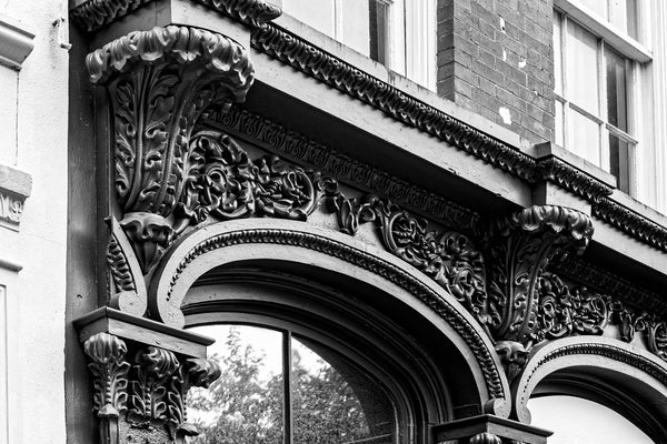 Black and white photograph of an ornate pressed metal commercial storefront found near the old Charleston City Market on Meeting Street. These fancy metal façades were produced in cities like St. Louis and shipped by boat, train, or wagon to be installed on the property.