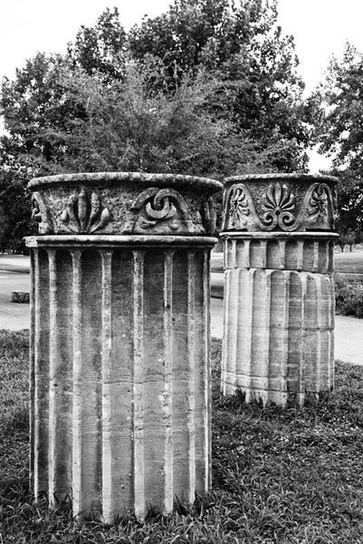Black and white photograph of two standing Greek Revival columns in Nashville. Originally part of the Tennessee State Capitol building, these columns were removed during a renovation and have been scattered around Nashville as a reminder of its reputation as "the Athens of the South."