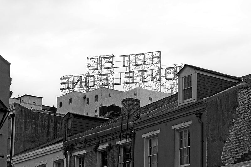 Black and white photograph of rooftop sign of the Hotel Monteleone, seen from behind, in New Orleans' famous French Quarter.