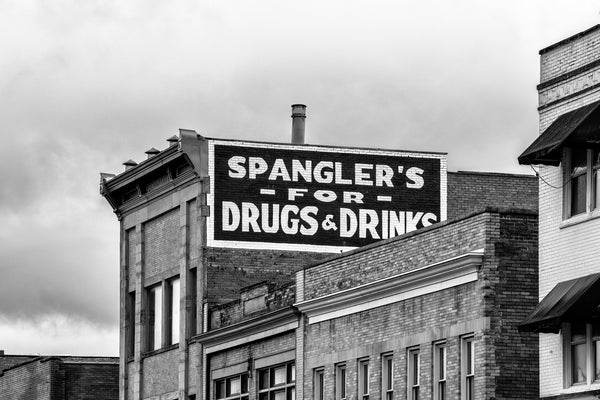 Black and White Photograph of the E.B. Spangler Building located in the historic downtown of Princeton, West Virginia. Formerly a pharmacy, the old sign says "Spangler's for Drugs & Drinks."