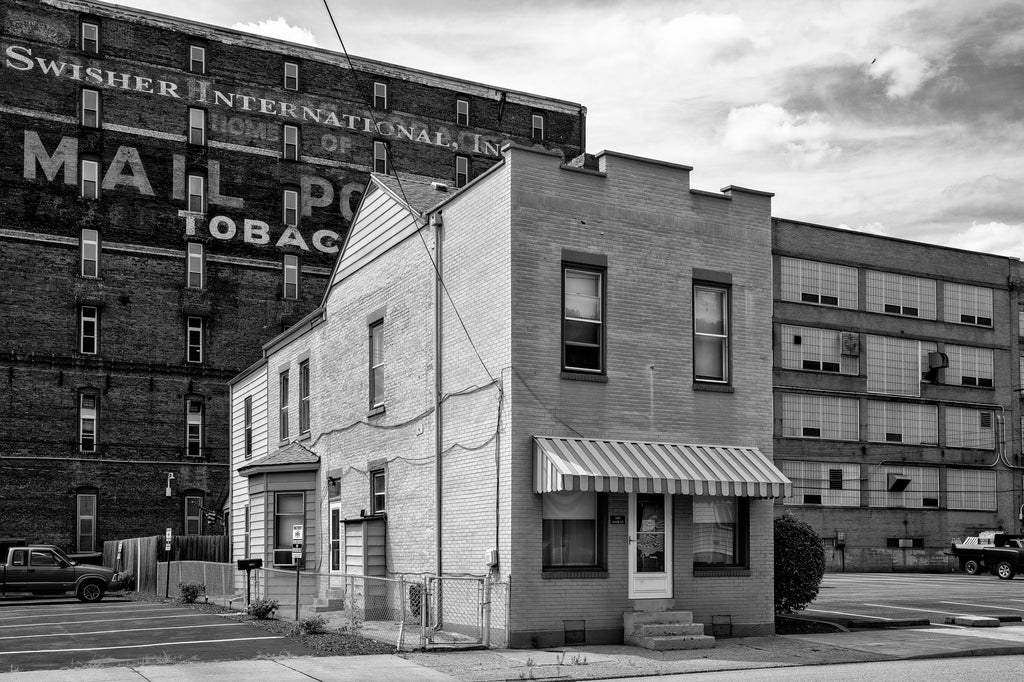 Black and white photograph of an old house, built 1880 with additions in the 1950s, located on the property of a tobacco manufacturing plant in South Wheeling, West Virginia.