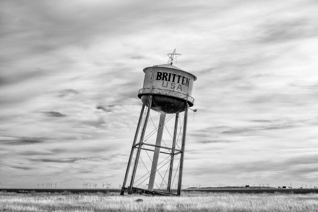 Black and white photograph of the famous road-side attraction called the "Leaning Tower of Texas," seen along I-40 in the Texas Panhandle.