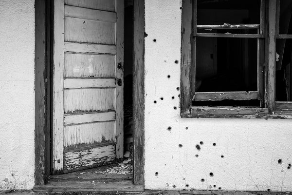 Black and white photograph of an abandoned motel with bullet holes found along old Route 66 in the Texas Panhandle