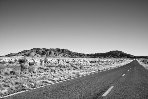 Black and white photograph of a lonesome highway through the New Mexico desert.  This is the picturesque County Road 349 near White Oaks, New Mexico.