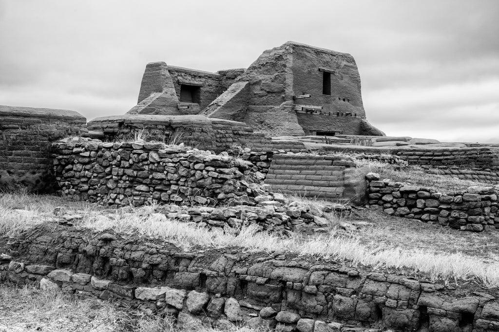 Black and white photograph of the ruins of an old Spanish adobe mission church built 1717 in the Sangre de Cristo Mountains of New Mexico.