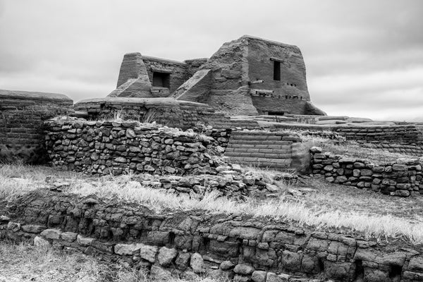 Black and white photograph of the ruins of an old Spanish adobe mission church built 1717 in the Sangre de Cristo Mountains of New Mexico.