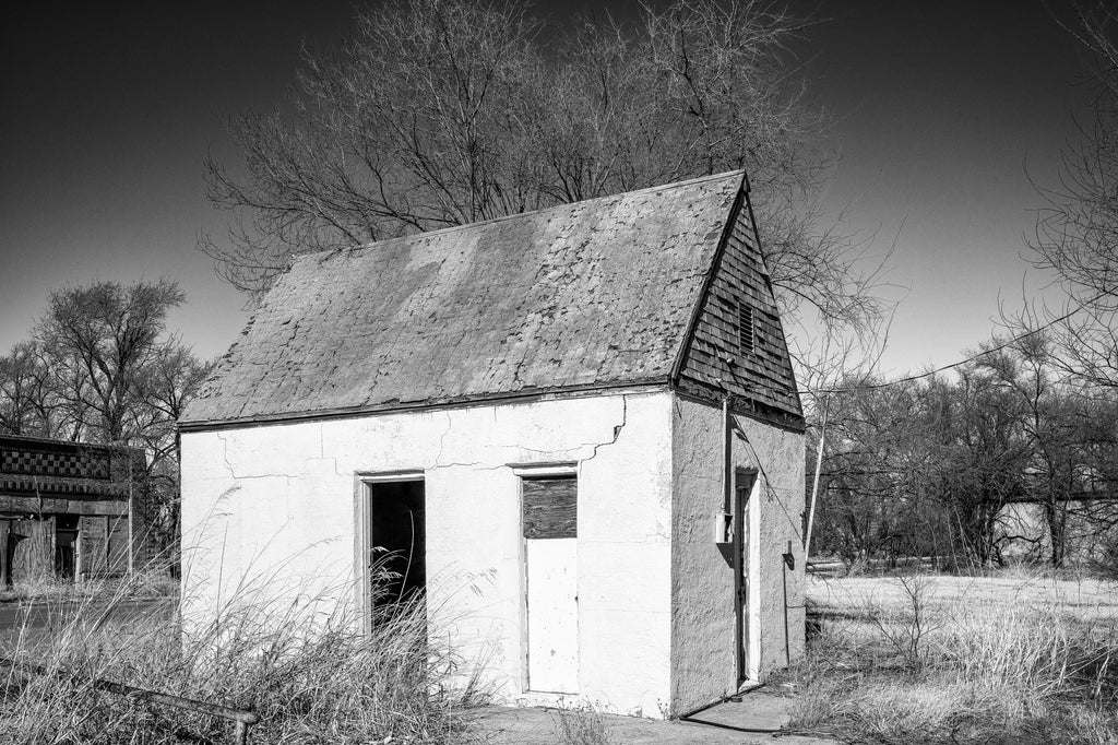 Black and white photograph of the ruins of an abandoned gas station building on old Route 66 in Texola, Oklahoma.