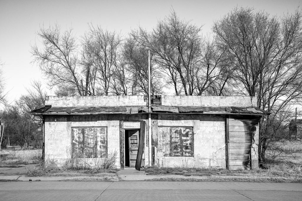 Black and white photograph of an abandoned building on old Route 66 in Oklahoma that was once home to a restaurant called the Friendly Cafe.