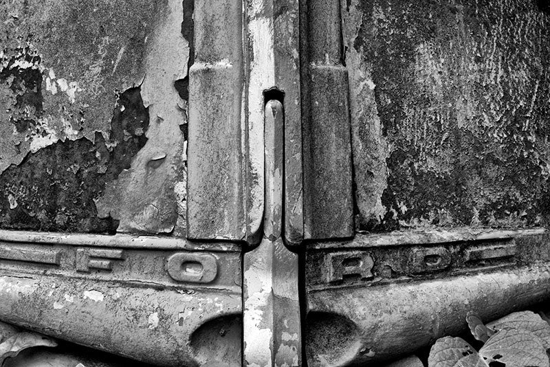 Black and white fine art photograph of a wrecked and abandoned delivery truck with a FORD emblem on the hood.