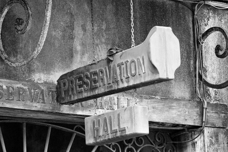 Black and white fine art photograph of the old trombone case sign that hangs over the entrance to the world-famous Preservation Hall in New Orleans' French Quarter.