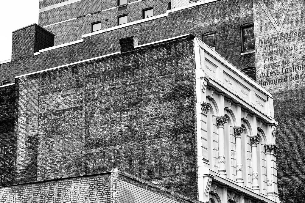 Black and white photograph of layers of antique fading advertising signs on the sides of the old Climax and Utopia Hotel buildings in downtown Nashville.