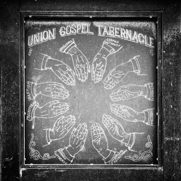Black and white photograph of an old sign for the  Union Gospel Tabernacle — which later became the world-famous Ryman Auditorium — in Nashville. Its origins as a church and its clearly non-secular architecture led to the Ryman's nickname, "The  Mother Church of Country Music." 