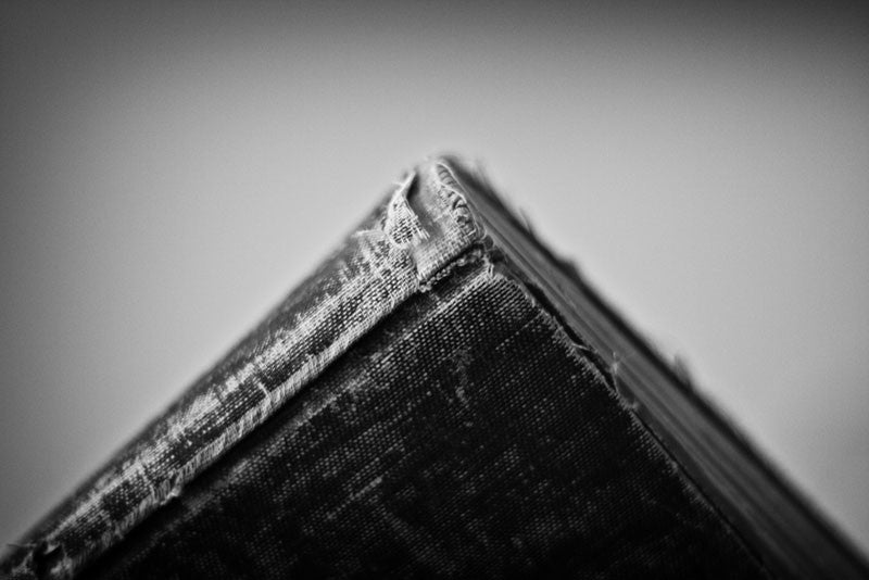 Black and white photograph of a tattered old history book, A Short History of England, published in 1904 and written by Edward P. Cheyney. This textbook was once owned by school girl Iva Carter of Greenville, Texas, who left her personal handwritten notes throughout the pages and inside covers. In some places, notes layer over notes, and over even more layers of notes.