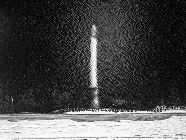 Black and white photograph of a candle abstracted by the textured window glass of a historic Church in the Adirondack region of upstate NY
