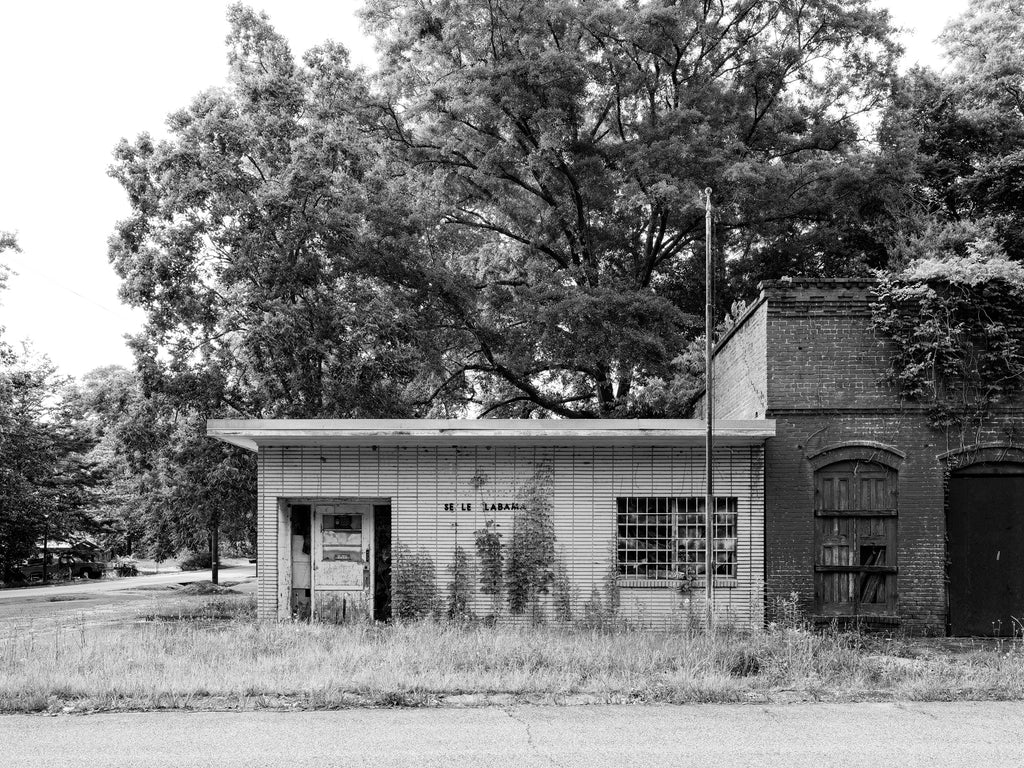 Black and white photograph of an abandoned U.S. Post Office that was probably in operation from 1962 until the mid-90s in the small town of Seale, Alabama. It sits on a street where every building is now vacant and in ruins.