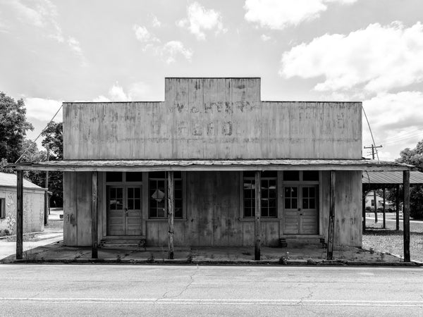 Black and white photograph of the abandoned storefront of the old W.B. Henry Feed Store in the small southern town of Leslie, Georgia