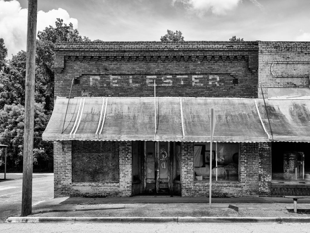 Black and white photograph of an abandoned historic storefront that once sold clothing and shoes in the totally vacant downtown area in the small community of Bartow, Georgia.