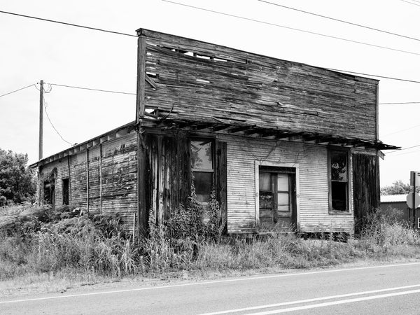 Black and white photograph of the front of an old wooden general store found at the crossroads in the small southern town of Smithville, Arkansas.