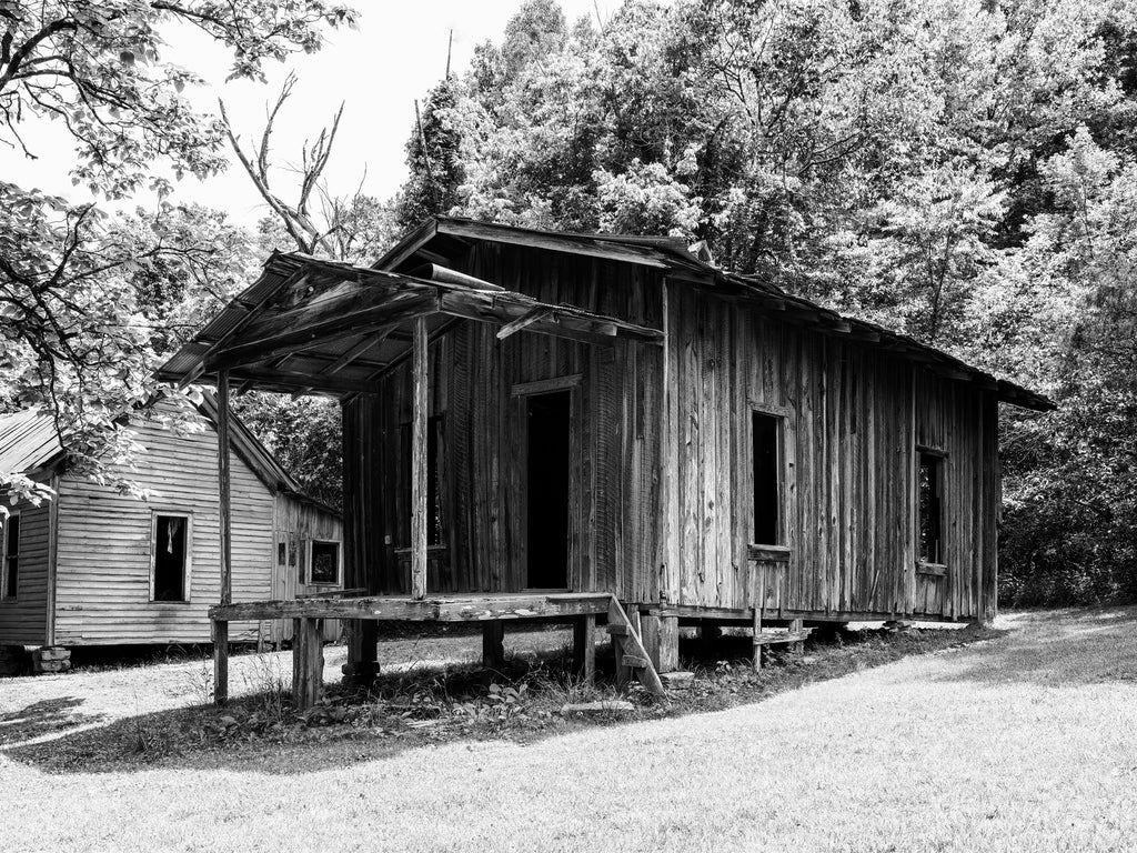 Black and white photograph of an abandoned historic miner's cabin in the abandoned zinc mining ghost town at Rush, Arkansas.